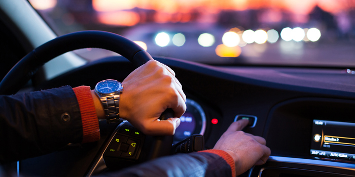 Interior de veículo citadino com condutor em marcha ao fim do dia 