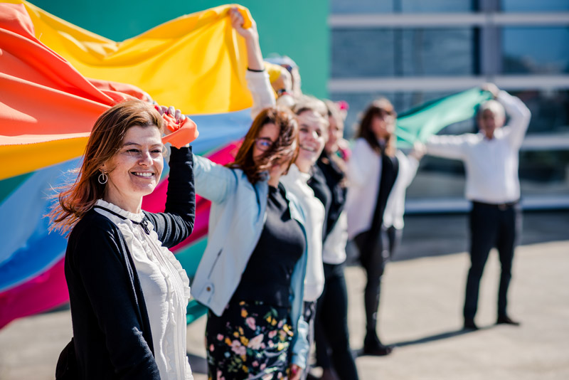 Equipa do Grupo Ageas Portugal segura bandeiras alusivas aos valores da marca