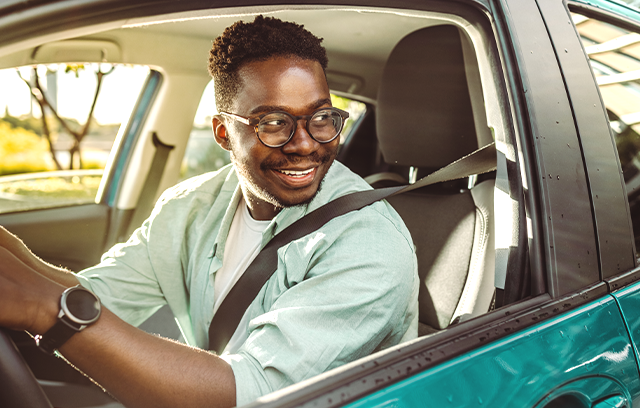 Condutor ao volante do seu carro durante uma viagem ao amanhecer