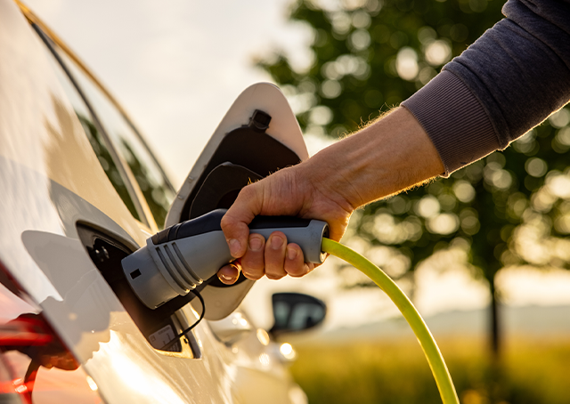 Mão de uma pessoa a carregar um carro elétrico